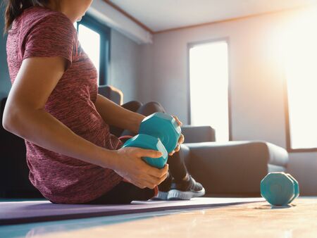 Good shape, strong and fit women in sportswear doing workout at home. Health care, people exercise and domestic living concept.の写真素材