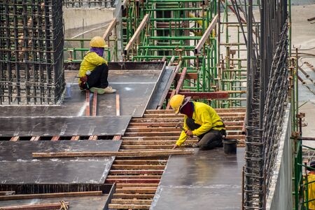 Construction man workers working on high building construction site. の写真素材