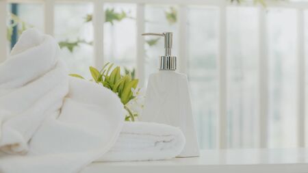 Shampoo and shower cream bottle with laundry white towel in bathroom with copy space.の写真素材