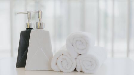 Shampoo and shower cream bottle with laundry white towel in bathroom with copy space.の写真素材