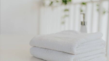 Laundry white towel with shampoo and shower cream bottle in bathroom with copy space.の写真素材