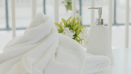 Shampoo and shower cream bottle with laundry white towel in bathroom.の写真素材