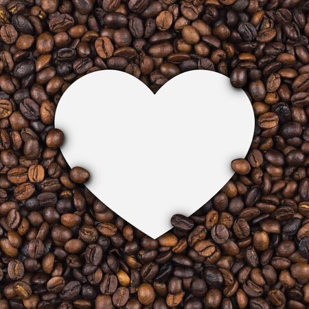 Closeup of empty white label paper on heap of roasted coffee beans for use as coffee web banner, coffee shop sign or cafe.の写真素材