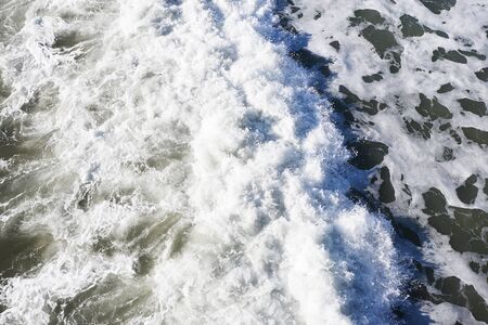 top view of foam of coastal wave when it hit a beach