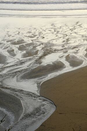 sand pattern from a creek flowing on a beach