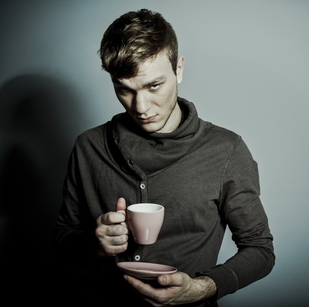 A young man with a cup of coffeeの写真素材