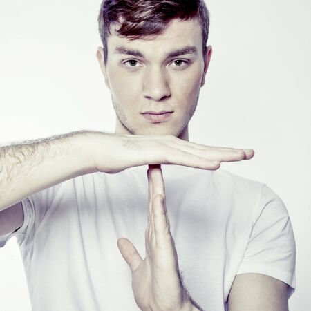 Portrait of young man gesturing time out sign