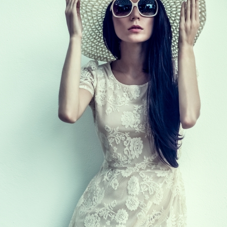 fashion portrait of a sensual girl in a hat against the wallの写真素材
