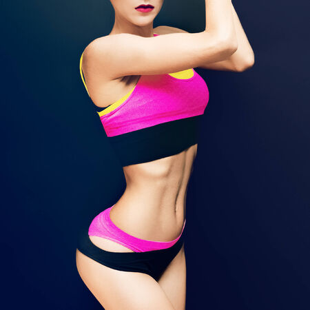 Slim athletic fitness girl on a black background in the fashion sportswearの写真素材