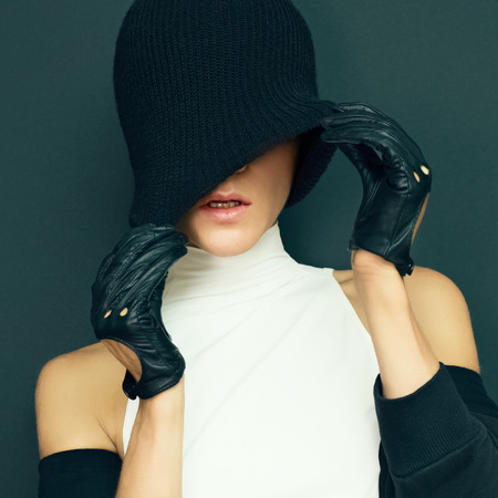 glamor model on black background in trendy gloves and hat autumn fashion styleの写真素材