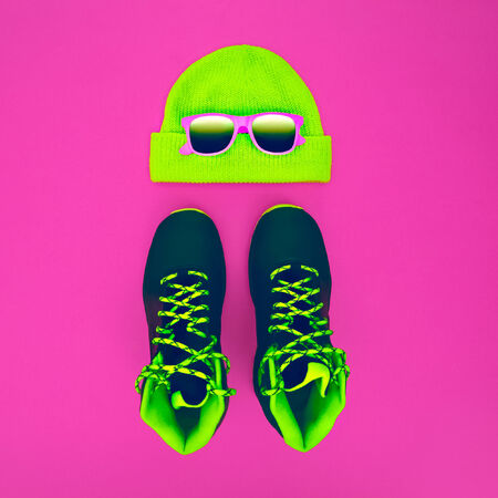 Stylish fashion sport accessories: sneakers, sunglasses, hat on crimson backgroundの写真素材