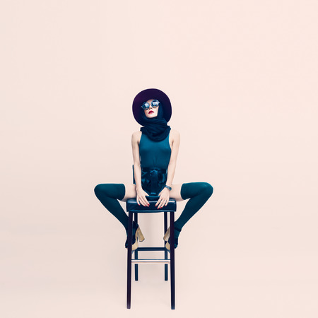 Sensual lady in a white room sitting on a chair. Loneliness and glamor styleの写真素材