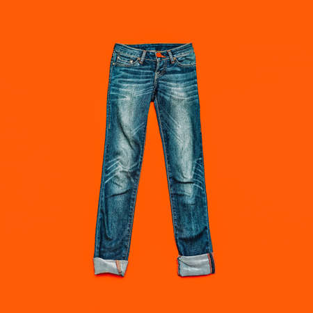 Blue jeans on bright orange backgroundの写真素材