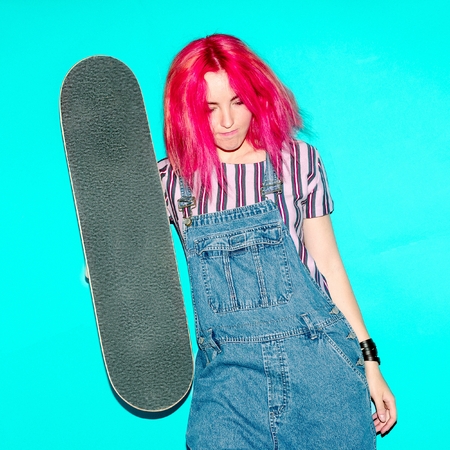 teen girl with pink hair and skateboard Urban Style Jeans Fashionの写真素材