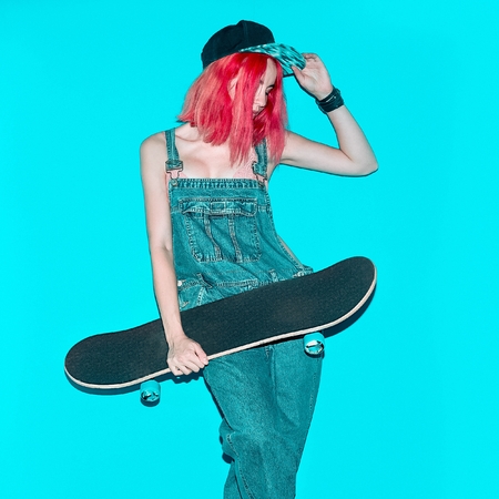 Pretty Teenager girl with pink hair and skateboard Urban Style Jeans Fashionの写真素材