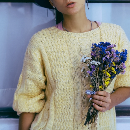 Sensual lady with bouquet fall. Knitted sweater. City Style.
