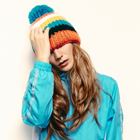 Stylish brunette in a hat with pompon Snowboard fashionの写真素材