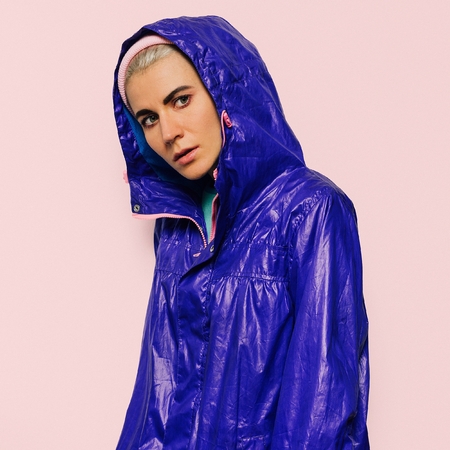 Hipster model in bright jacket hood sport style urban Outfitの写真素材