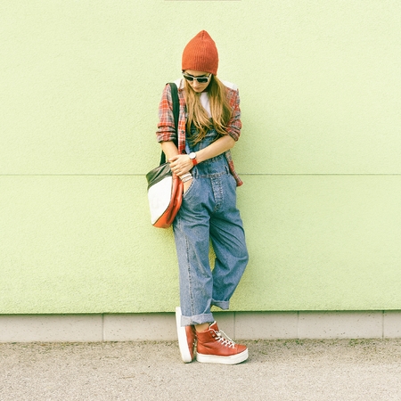 Fashion Autumn Style. Student girl at the wall in a stylish clothesの写真素材