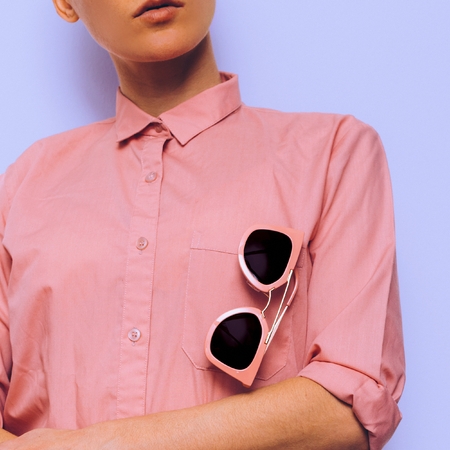 Girl in a pink shirt and pink sunglasses. Stylish clothesの写真素材