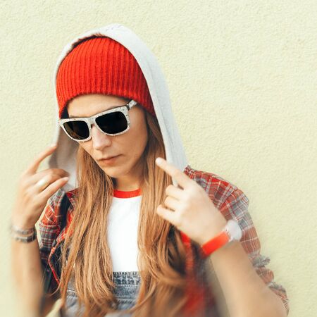 Stylish Autumn. Brunette in fashion accessories. Cap, sunglasses hoodの写真素材