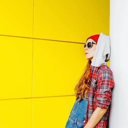 Stylish Urban girl in shirt and denim overalls in the cityの写真素材