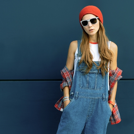 Stylish brunette in red hat and denim in urban locationsの写真素材