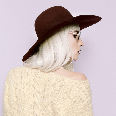 Blonde girl in a fashionable hat. Stylish accessories of the seasonの写真素材