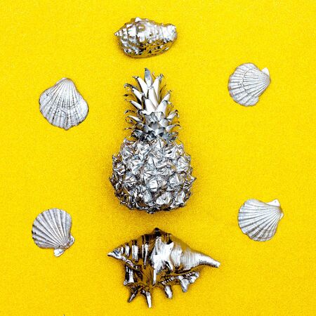 Tropical set. Pineapple and seashells on a gold background. Minimal