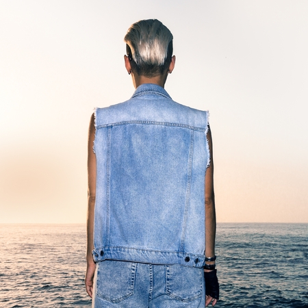 girl in stylish denim outfit sea background sunsetの写真素材