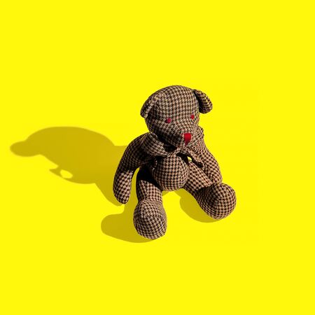 Vintage bear toy on yellow background