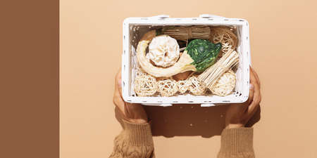 Woman Hands hold stylish red clutch on design background. Accessories fashion concept, Copy space. Fall winter season. Beige brown warm mood. Stylish strong shadows designの写真素材