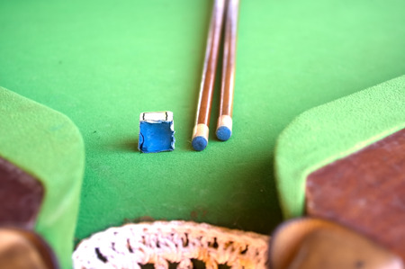 Billiard cue and chalk on table