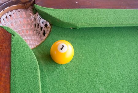 yellow ball near hole on pool game