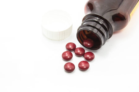 Prescription pill bottle spilling pills isolated on white background