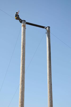 Man about to fall off from a 60-foot poleの写真素材