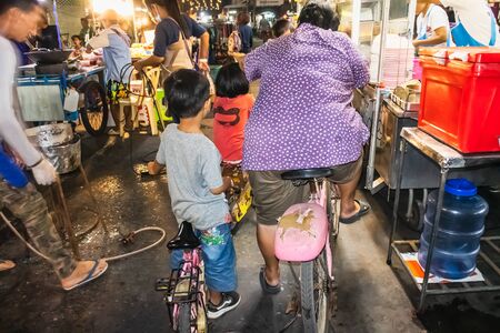 People on bicycle in food street at Rong Thong Shrine Wiset Chai Chan District Ang Thong Thailand, March 29, 2019のeditorial素材