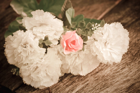 Rose and white lily flowers on wooden backgroundの写真素材