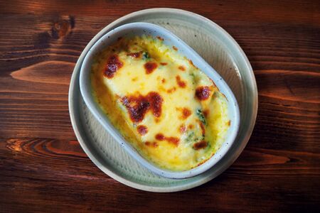 Baked spinach with cheese with top view on wood table.の写真素材