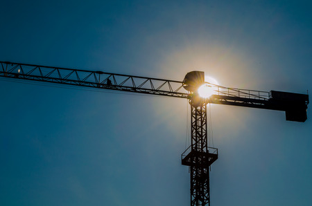 Construction cranes and sunの写真素材