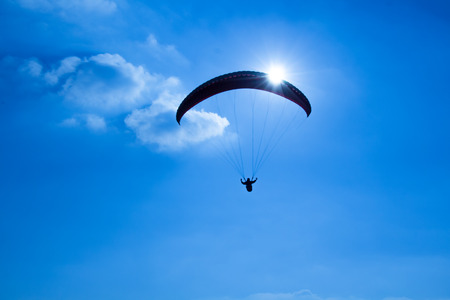 Paraglider on the blue sky in the sun and clouds.の写真素材