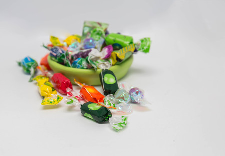 Many candy in a ceramic cup on a white background, like kids.