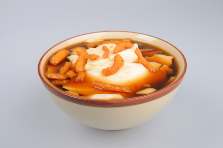 Chinese dessert made with white tofu serve with brown sugar and ginger.Sprinkle with Deep-fried dough stick known as "Patongo"の写真素材