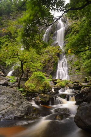 Waterfall with a pathway in green garden at Khlong Lan Waterfall, KamphaengPhet, Thailandの写真素材