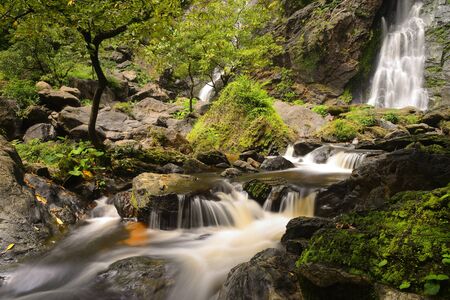 Waterfall with a pathway in green garden at Khlong Lan Waterfall, KamphaengPhet, Thailandの写真素材
