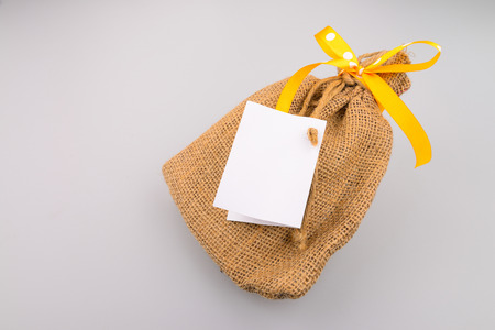sack gift bag with ribbon bow, and white papers.の写真素材