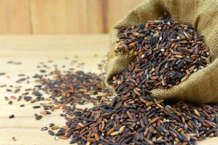 long grain rice,brown rice,on wood backgroundの写真素材
