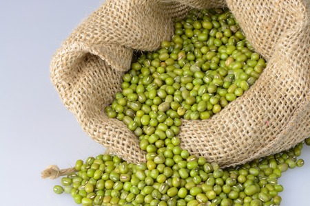 Mung bean seeds spilling from a sack.の写真素材