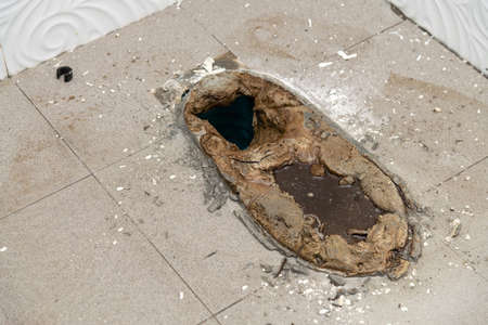 Old toilet base, demolish old tiles a bathroom with jackhammer,  toilet repair,  remodeling, renovation, overhaul, extension, restoration and reconstructionの写真素材