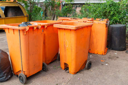 Orange rubbish bin in a public place. essential equipment to keep the environment clean and comfortable, Orange Plastic Waste Container Or Wheelie Bin.の写真素材
